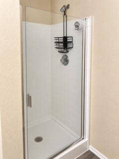 Walk-in shower with clear glass enclosure, white subway tile surround, and a chrome shower fixture