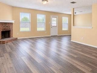 Wood-finish flooring throughout, brick fireplace with mantel, multiple windows with blinds, and recessed lighting