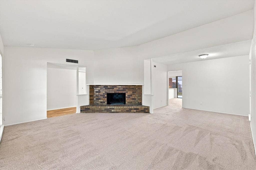 411 Clear Creek Lane, Coppell, TX 75019 Spacious living area with tall ceilings and a cozy wood-burning fireplace.