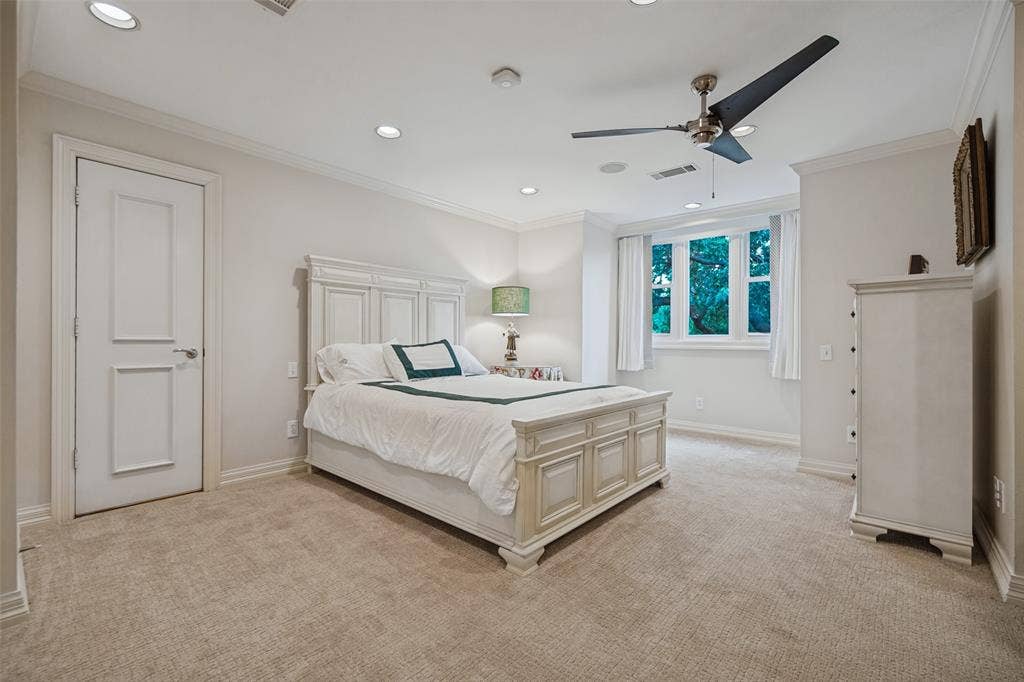 Upstairs primary bedroom with recessed lighting, crown molding, broadloom carpet, multi-pane window, and a ceiling fan with integrated lighting
