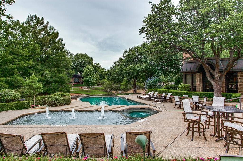 Expansive outdoor space featuring a swimming pool, integrated spa, and fountain
