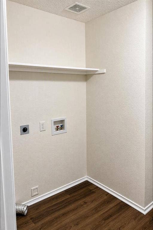 Dedicated utility area featuring a built-in shelf, wood-finish flooring, and essential appliance hookups