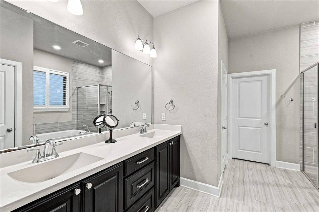 5441 Caine Road, Richardson, TX 75082 Dual vanity with dark wood cabinetry, white countertops, and undermount sinks