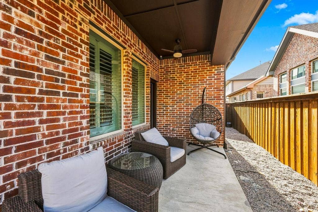 5441 Caine Road, Richardson, TX 75082 Covered patio featuring a brick exterior wall, concrete flooring, and a ceiling fan
