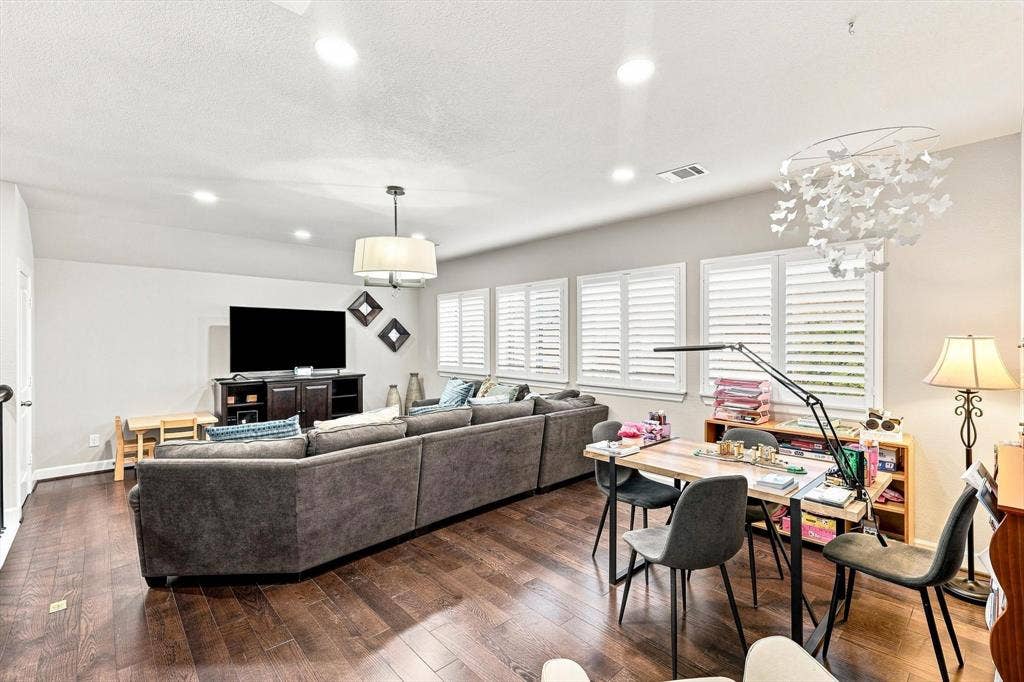 5441 Caine Road, Richardson, TX 75082 Spacious interior with wood-finish flooring, recessed lighting, and multiple windows featuring plantation shutters