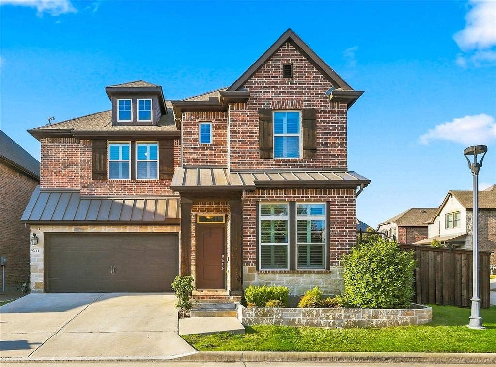 5441 Caine Road, Richardson, TX 75082 Brick exterior with stone accents, gable roof, dormer window, covered entry, and attached garage