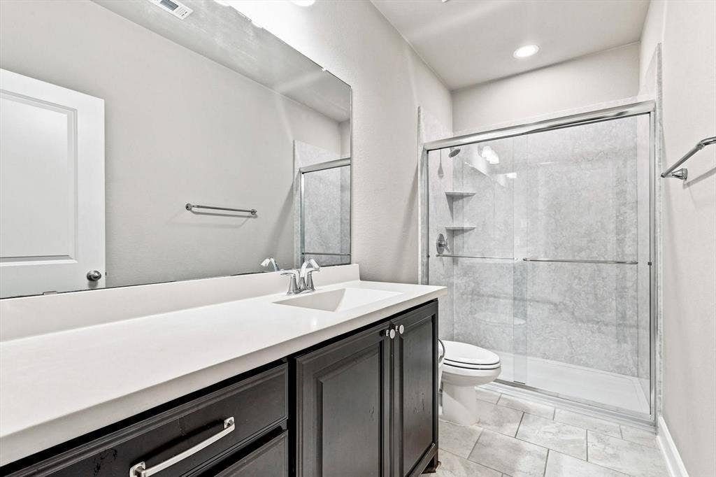 5441 Caine Road, Richardson, TX 75082 Spacious vanity with an integrated sink, dark wood-finish cabinetry, and a large mirror