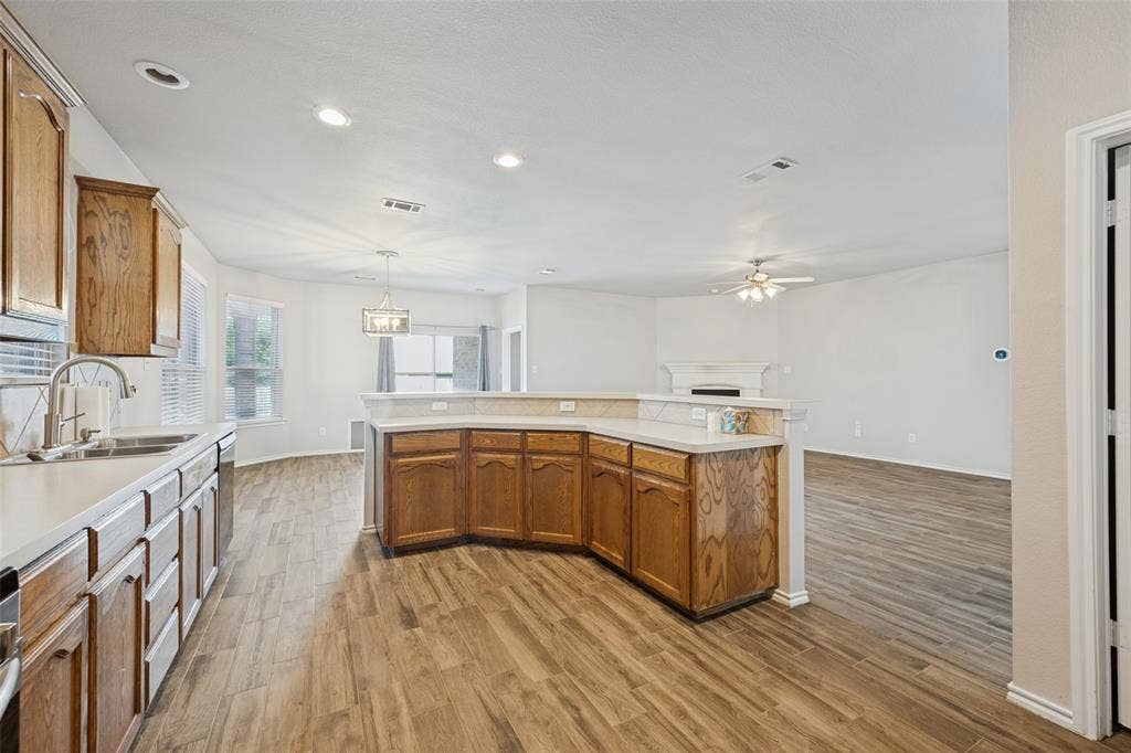 Kitchen featuring wood-finish flooring, wood cabinetry, white countertops, and recessed lighting