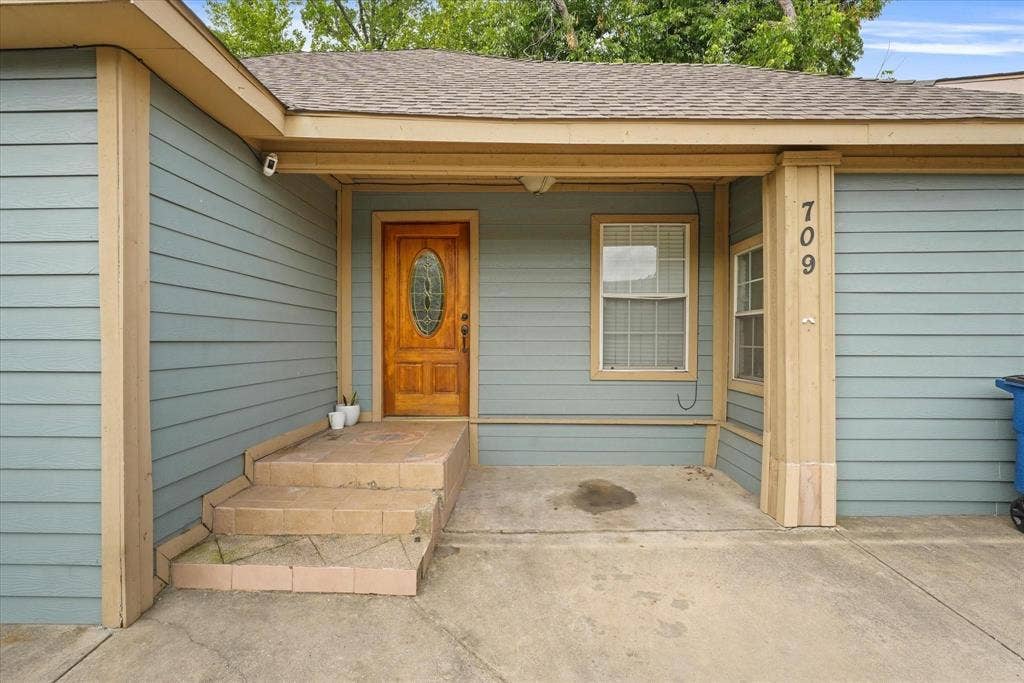 709 S Munger Boulevard, Dallas, TX 75223 Light blue siding exterior with tan trim accents