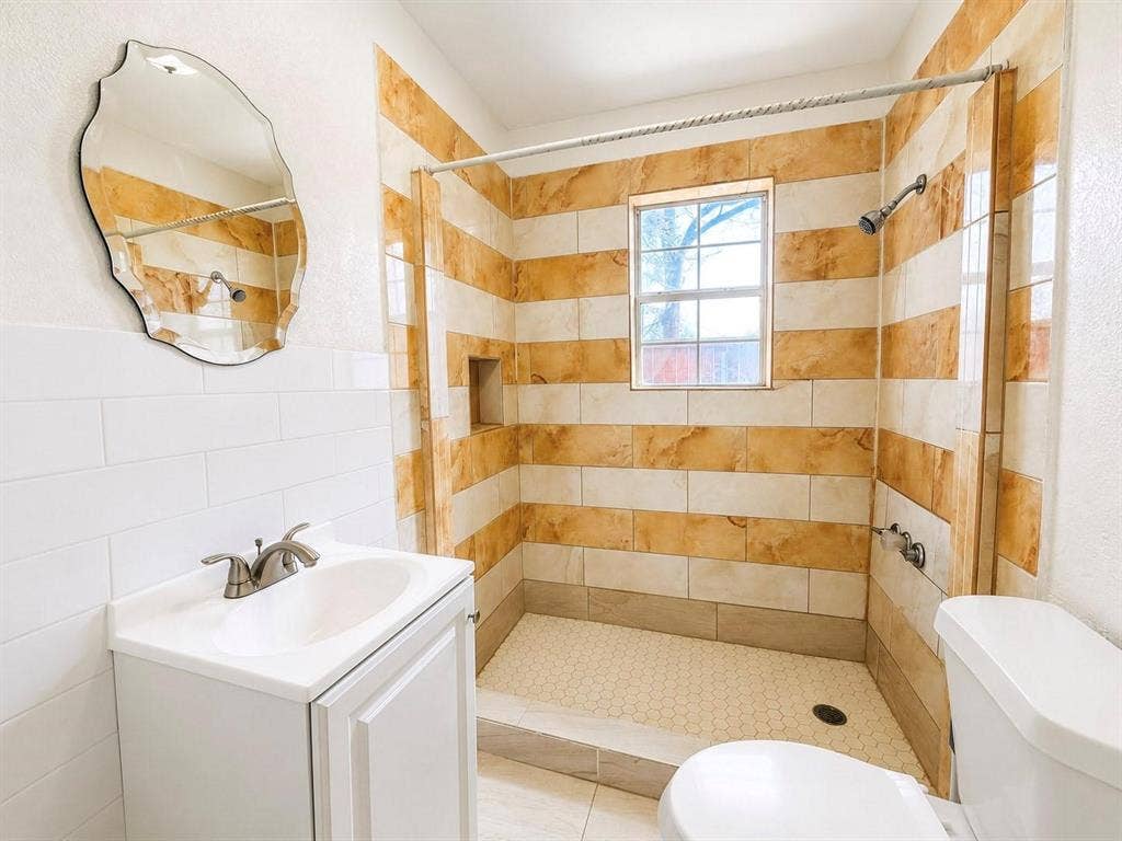 709 S Munger Boulevard, Dallas, TX 75223 Walk-in shower with horizontal striped tiling and recessed niche