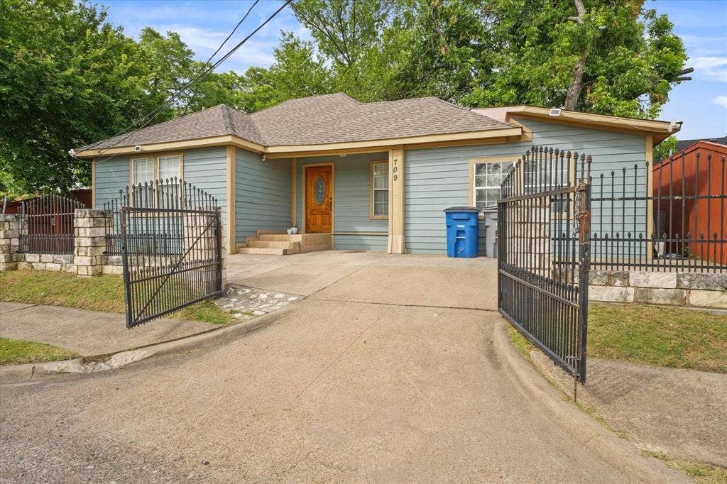 709 S Munger Boulevard, Dallas, TX 75223 Single-story exterior with light blue siding and a brown shingle roof