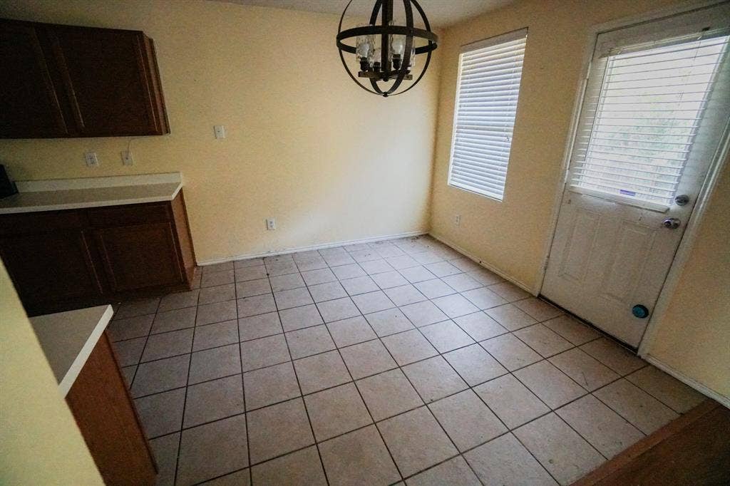 1517 Harvest Crossing Drive, Wylie, TX 75098 Tile flooring, wood-finish cabinetry, light-toned countertops, and a spherical light fixture