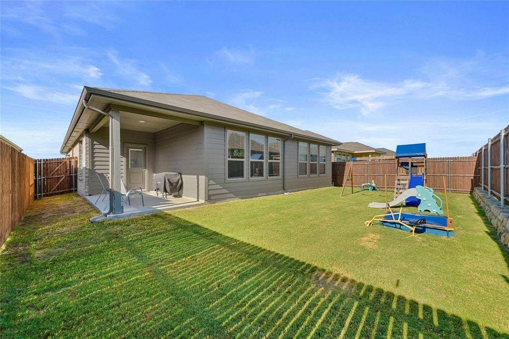821 Shepperton Way, Fort Worth, TX 76247 Back of property featuring a patio and a lawn