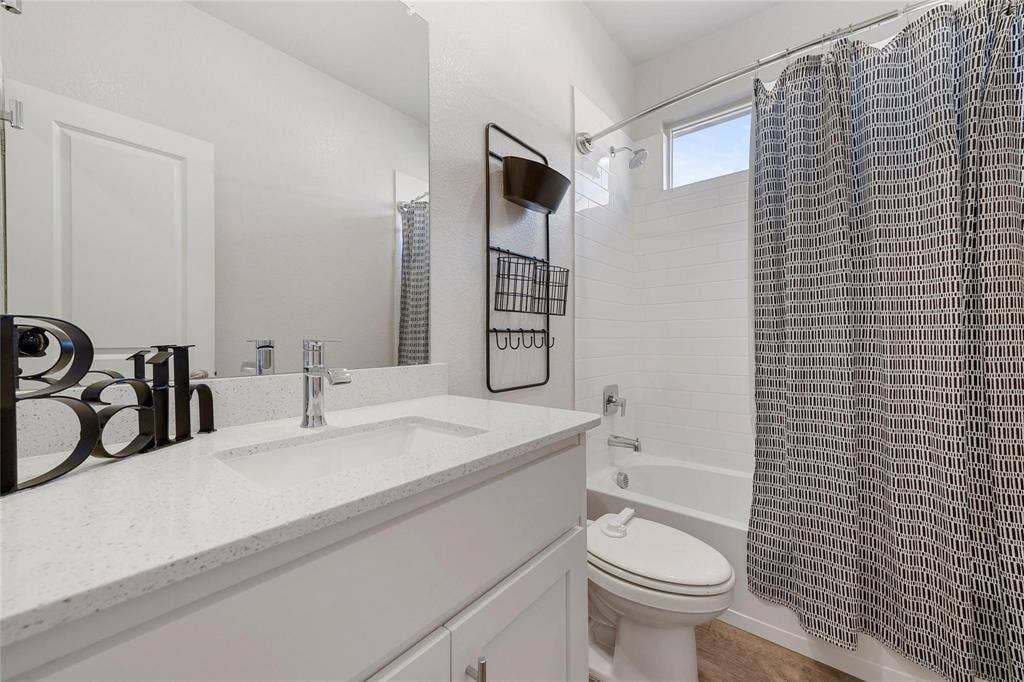 821 Shepperton Way, Fort Worth, TX 76247 Full bathroom with shower / bath combo with shower curtain, vanity, and toilet