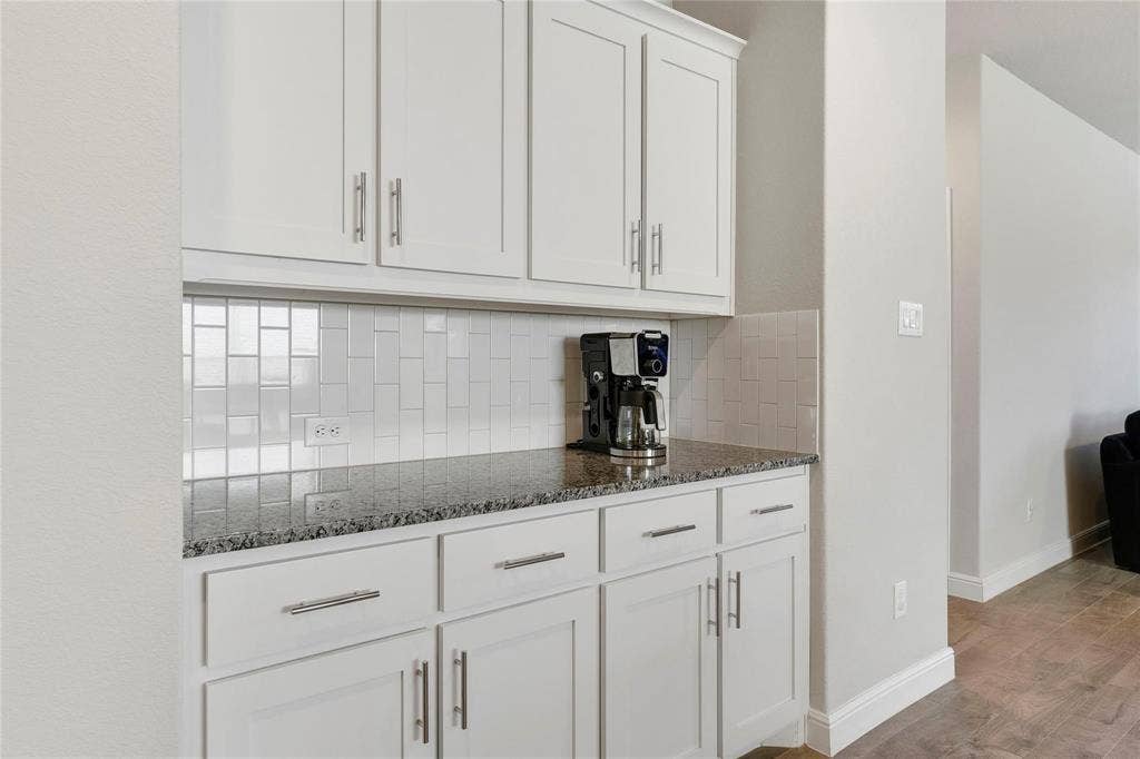 821 Shepperton Way, Fort Worth, TX 76247 Kitchen featuring white cabinets, light hardwood / wood-style floors, backsplash, and dark stone countertops