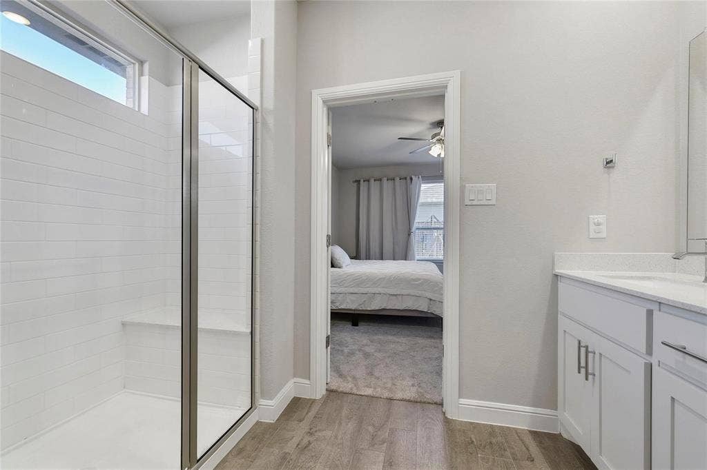 821 Shepperton Way, Fort Worth, TX 76247 Bathroom featuring ceiling fan, hardwood / wood-style flooring, a shower with door, and vanity
