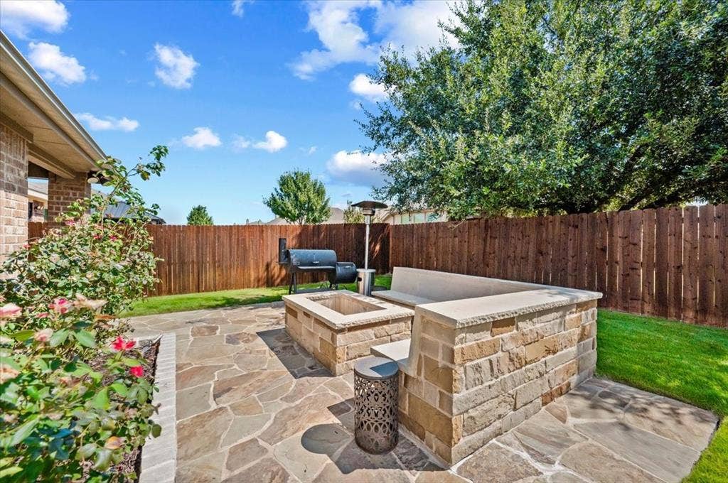 2225 Torch Lake Drive, Forney, TX 75126 Expansive flagstone patio with a built-in stone fire pit and integrated stone bench seating