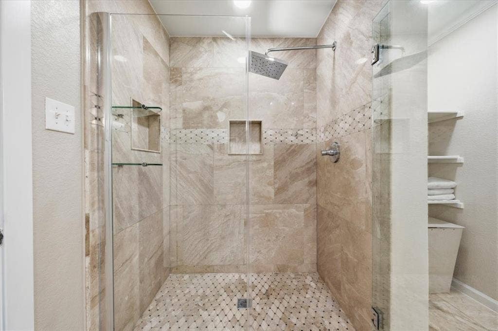2225 Torch Lake Drive, Forney, TX 75126 Glass-enclosed shower with large format wall tile, mosaic floor tile, built-in shower niches, and a rainfall showerhead