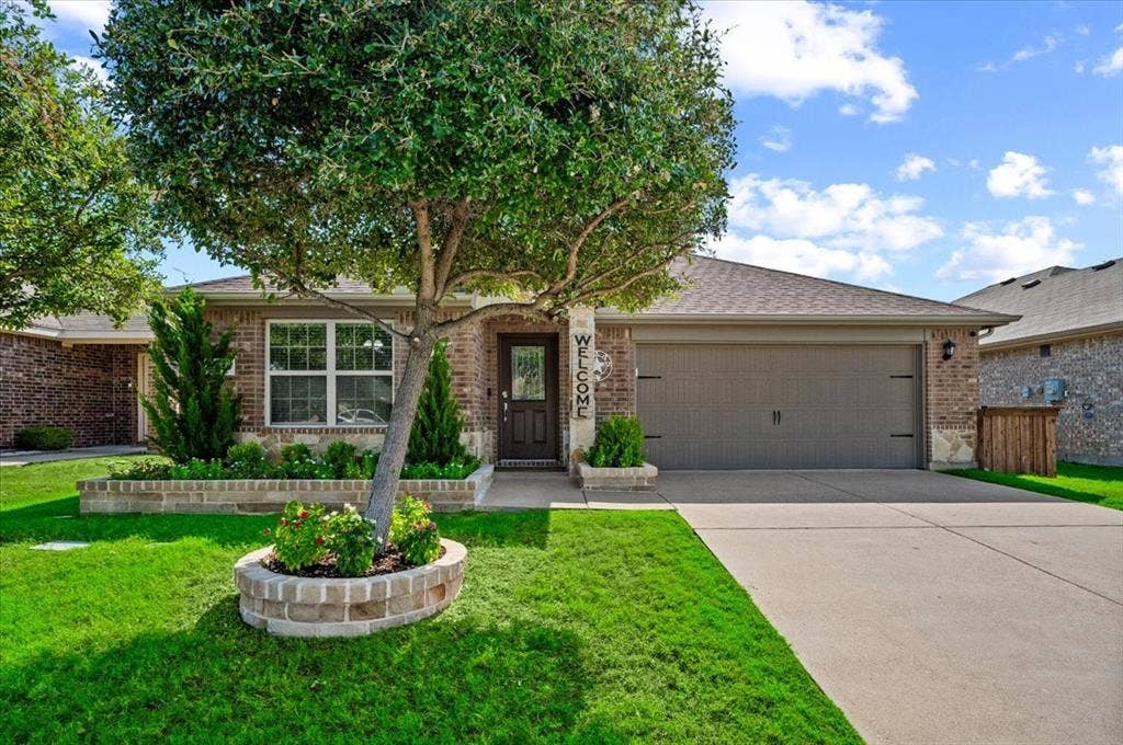 2225 Torch Lake Drive, Forney, TX 75126 Brick exterior with a gabled roof and attached garage