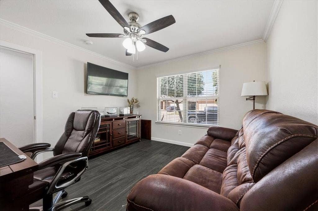 2225 Torch Lake Drive, Forney, TX 75126 White crown molding, dark wood-finish flooring, a ceiling fan with integrated lighting, and a large window with horizontal blinds