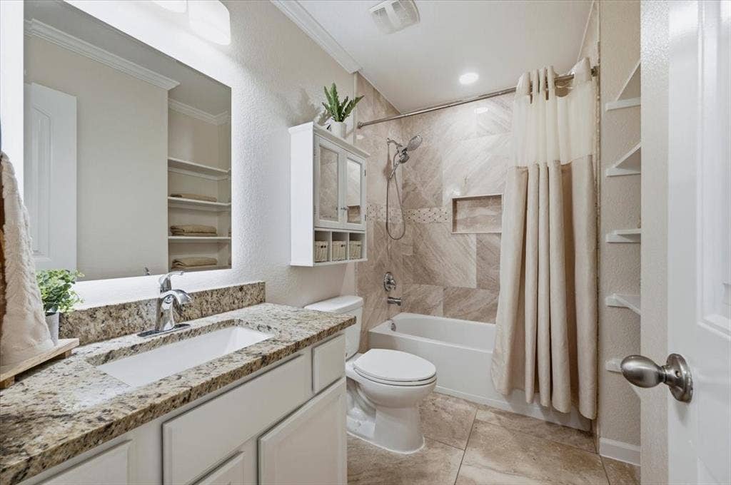 2225 Torch Lake Drive, Forney, TX 75126 Bathroom featuring a vanity with a rectangular undermount sink, granite countertop, built-in shelving, and a tiled tub/shower combination with a recessed niche