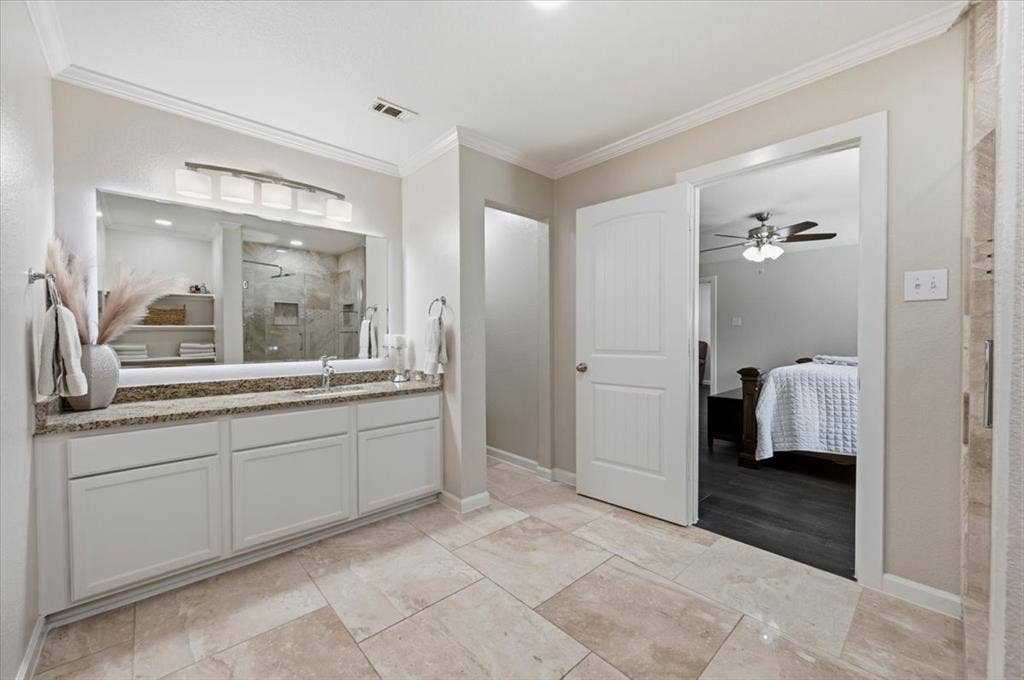 2225 Torch Lake Drive, Forney, TX 75126 Double vanity with a stone countertop, white cabinetry, and a large illuminated mirror