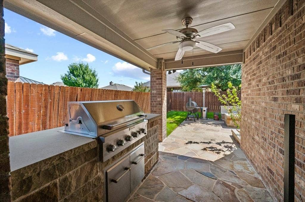 2225 Torch Lake Drive, Forney, TX 75126 Covered patio featuring a built-in outdoor grill, stone-finish counter, and a ceiling fan