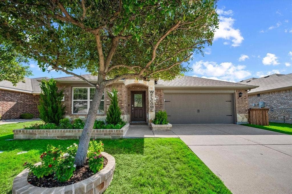 2225 Torch Lake Drive, Forney, TX 75126 Brick exterior with an arched entryway and dark wood-finish door