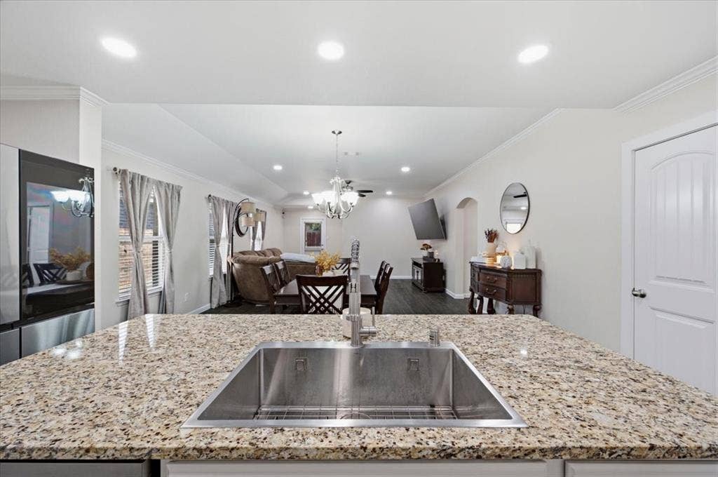 2225 Torch Lake Drive, Forney, TX 75126 Kitchen island with a stainless steel undermount sink, speckled countertop, and recessed lighting
