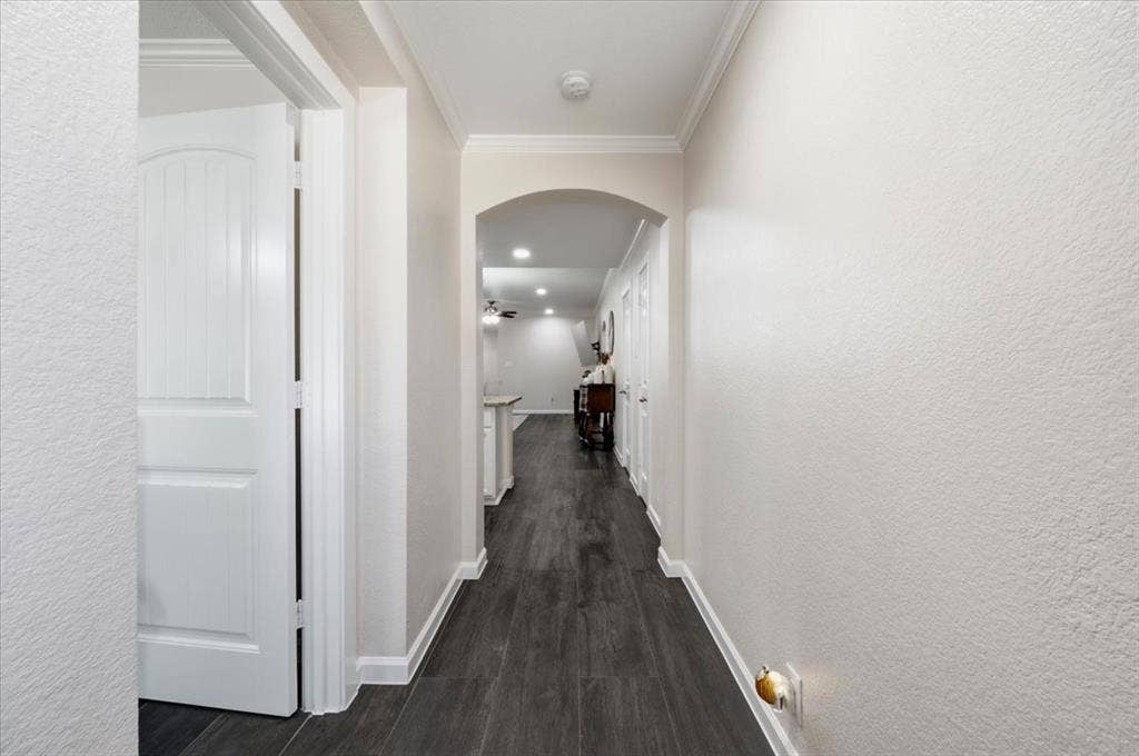2225 Torch Lake Drive, Forney, TX 75126 Hallway featuring wood-finish flooring, an arched entryway, and white trim