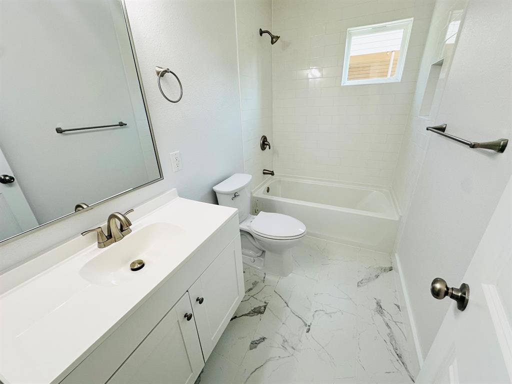 Vanity with integrated sink, sleek mirror, and modern brushed nickel hardware