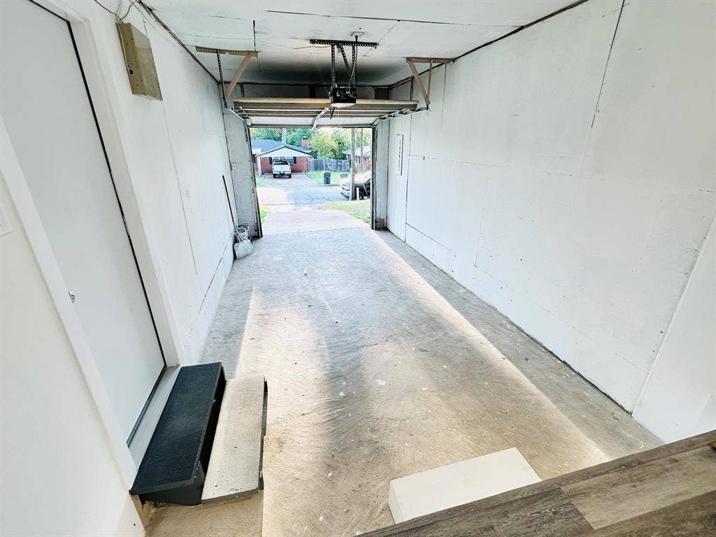 Attached garage with concrete flooring and a white overhead door