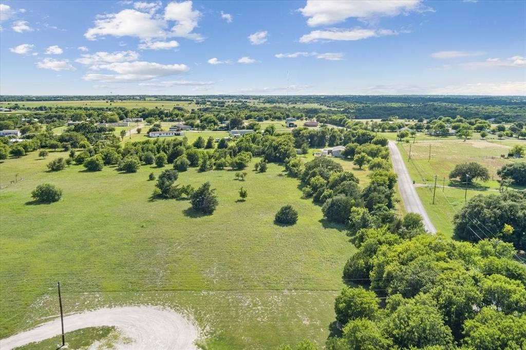 108 Brown Drive, Bruceville Eddy, TX 76524 Expansive green acreage with scattered mature trees and a curvilinear access road