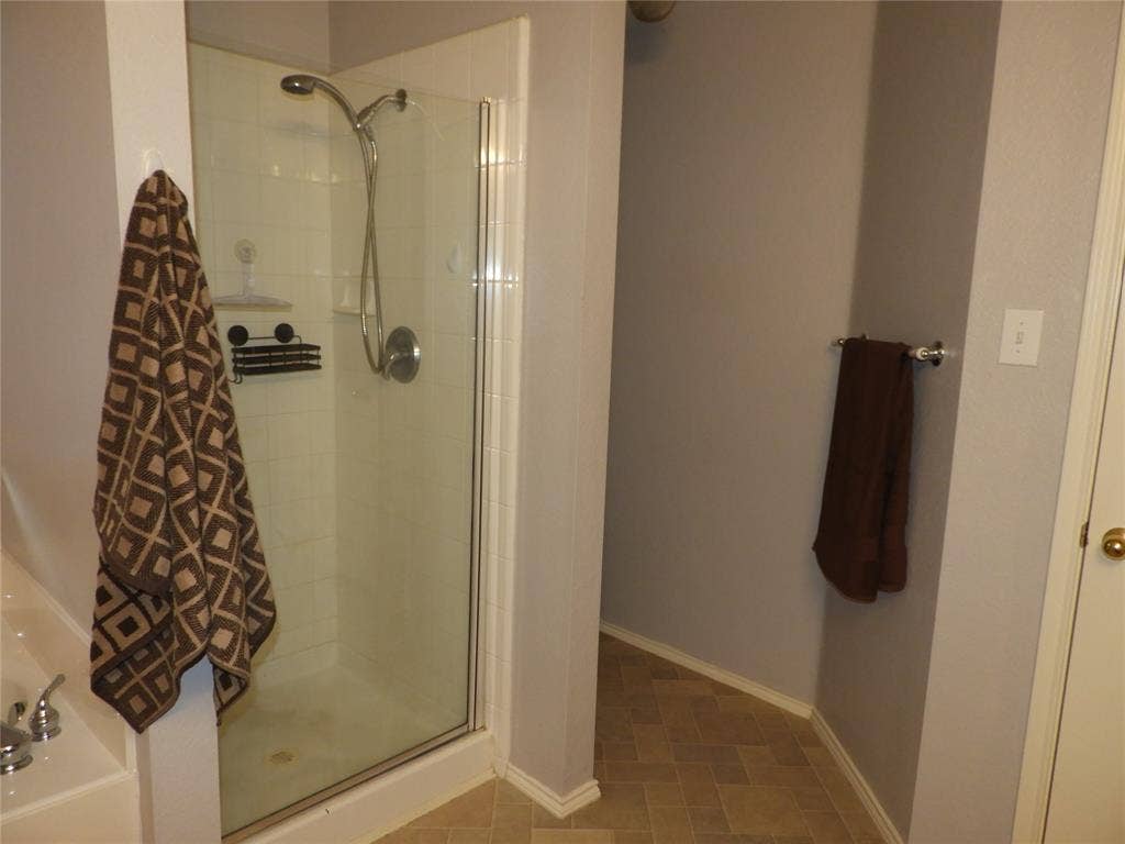 Another view of Primary Bathroom featuring standing shower and privacy space.