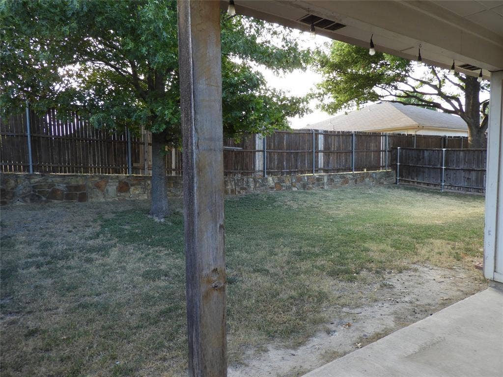 Spacious backyard with covered porch for covered enjoyment.