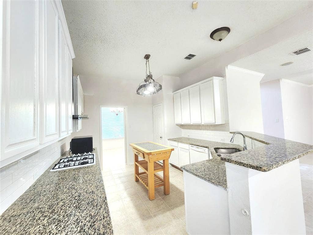 3625 Mason Drive, Plano, TX 75025 Kitchen featuring white cabinetry, stone countertops, stainless steel sink, and built-in stovetop