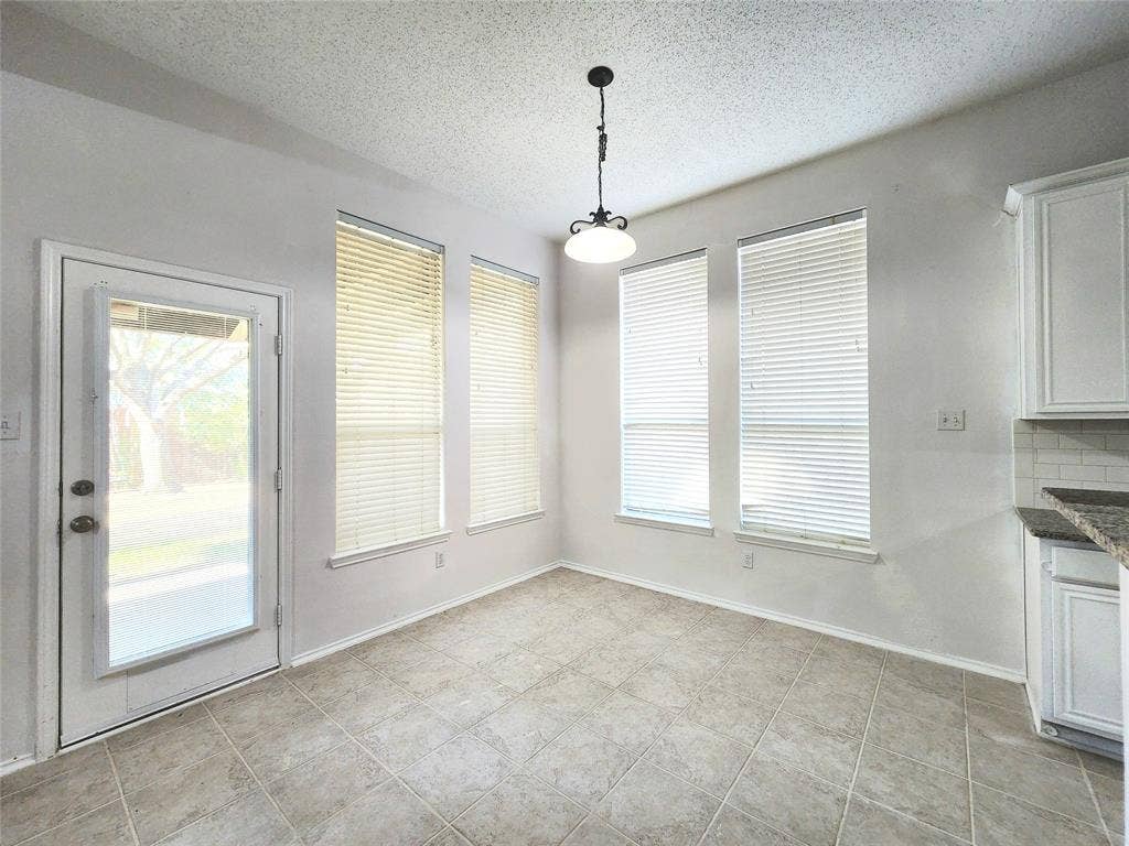 3625 Mason Drive, Plano, TX 75025 Tile flooring, multiple windows with blinds, white cabinetry, light-colored backsplash, and a pendant light fixture