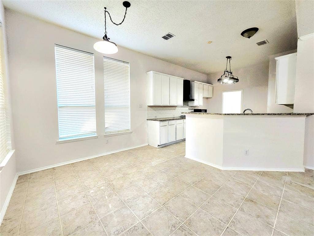 3625 Mason Drive, Plano, TX 75025 Spacious room with large windows, tile flooring, and a contemporary pendant light fixture