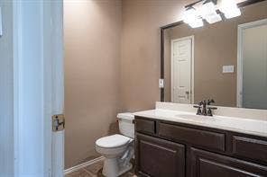 Bathroom featuring toilet, vanity, tile patterned flooring, and baseboards