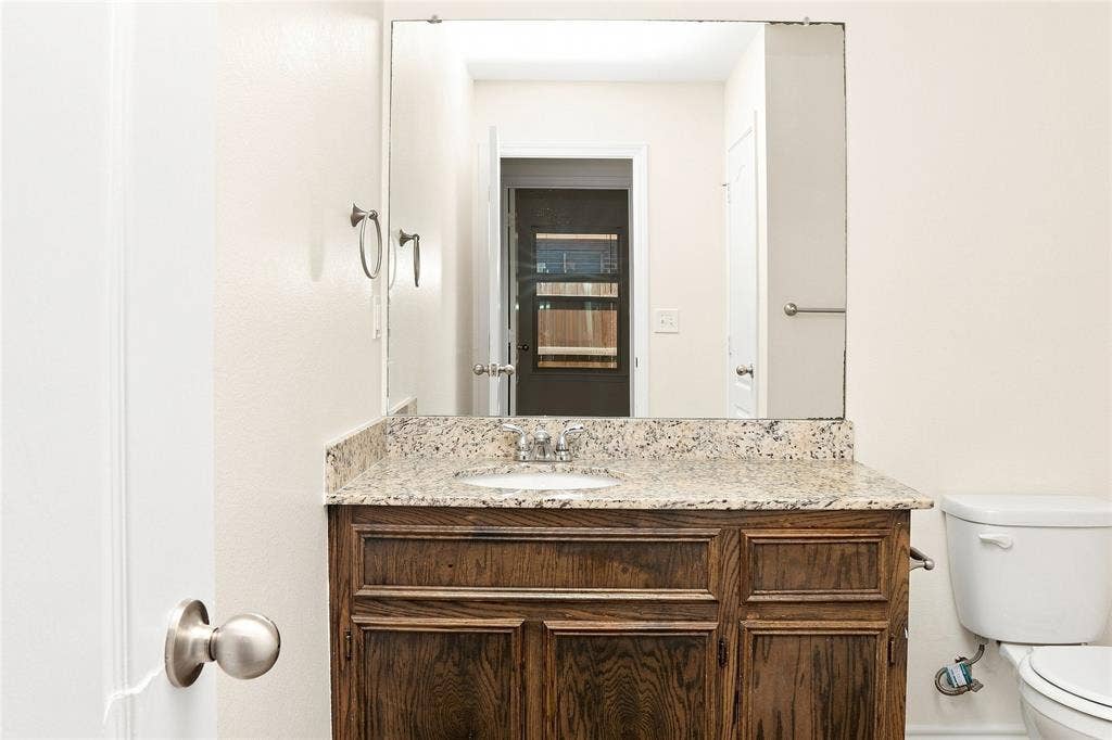 6015 Amelia Earhart Boulevard, #B, Killeen, TX 76543 Wood-finish vanity with a granite countertop, undermount sink, and brushed nickel hardware