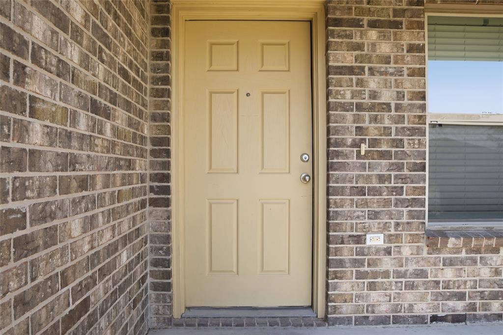 6015 Amelia Earhart Boulevard, #B, Killeen, TX 76543 Brick exterior with a paneled entry door and an adjacent window with blinds