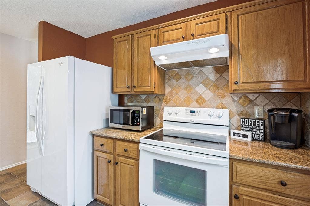 Wood-finish cabinetry paired with a patterned tile backsplash