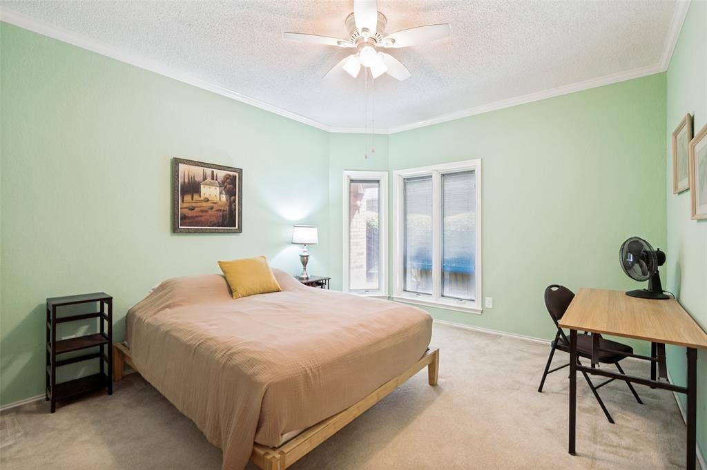 Recessed bay window, ceiling fan, crown molding, and wall-to-wall carpeting