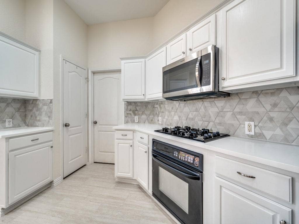 6551 Fairlawn Drive, Frisco, TX 75035 Gas cooktop and oven. Built in microwave. Updated quartz countertops. Built in pantry.