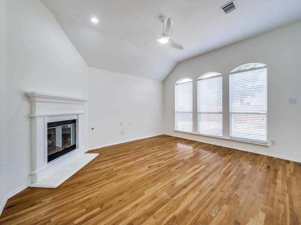 6551 Fairlawn Drive, Frisco, TX 75035 Main living room with gas fireplace and picture windows looking out over the backyard.
