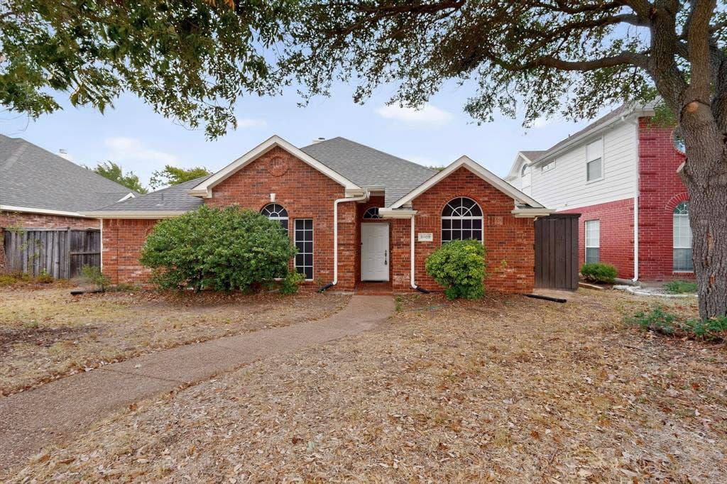 8108 Case Drive, Plano, TX 75025 Brick exterior with a white entry door, arched windows, and a gabled roofline
