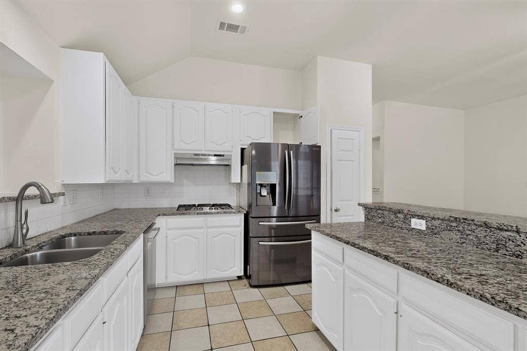 8108 Case Drive, Plano, TX 75025 Kitchen featuring white cabinetry, speckled countertops, a double basin stainless steel sink, and stainless steel appliances