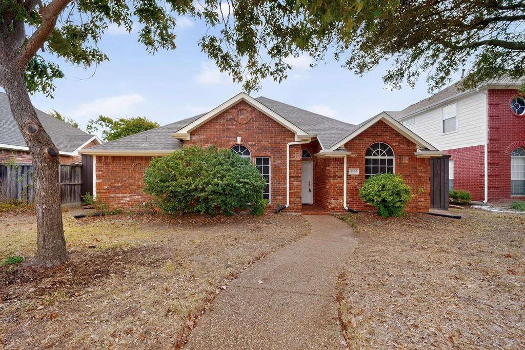 8108 Case Drive, Plano, TX 75025 Brick exterior featuring a gabled roofline, arched windows, and a concrete pathway