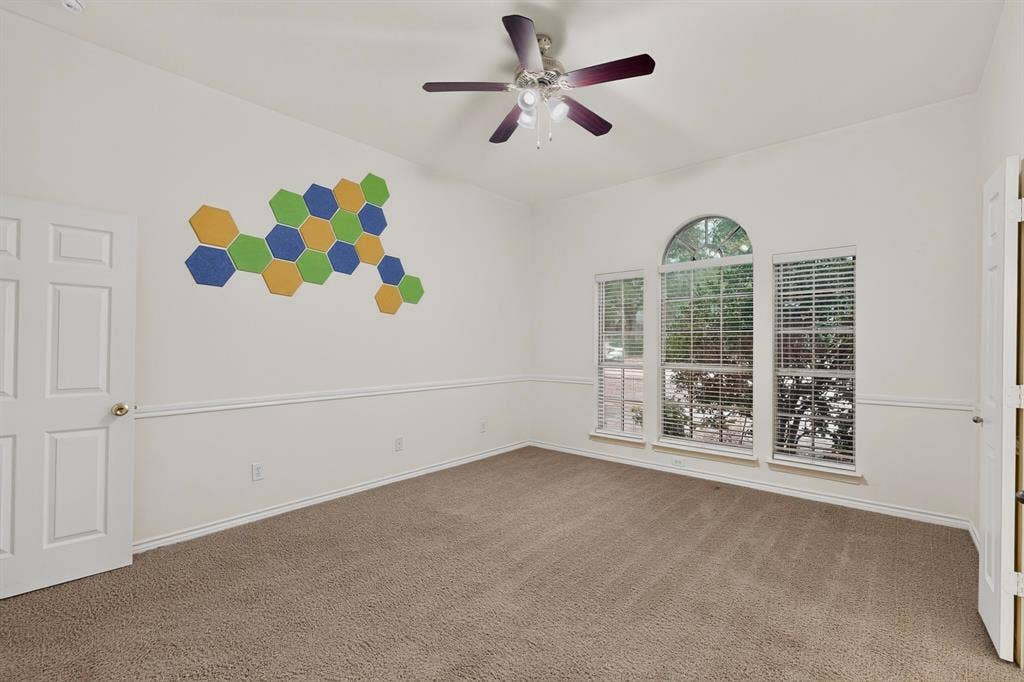 8108 Case Drive, Plano, TX 75025 Arched window with two flanking windows, ceiling fan, and neutral carpet