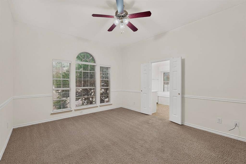 8108 Case Drive, Plano, TX 75025 High ceilings, arched window accent, neutral carpet, bi-fold doors, and a ceiling fan